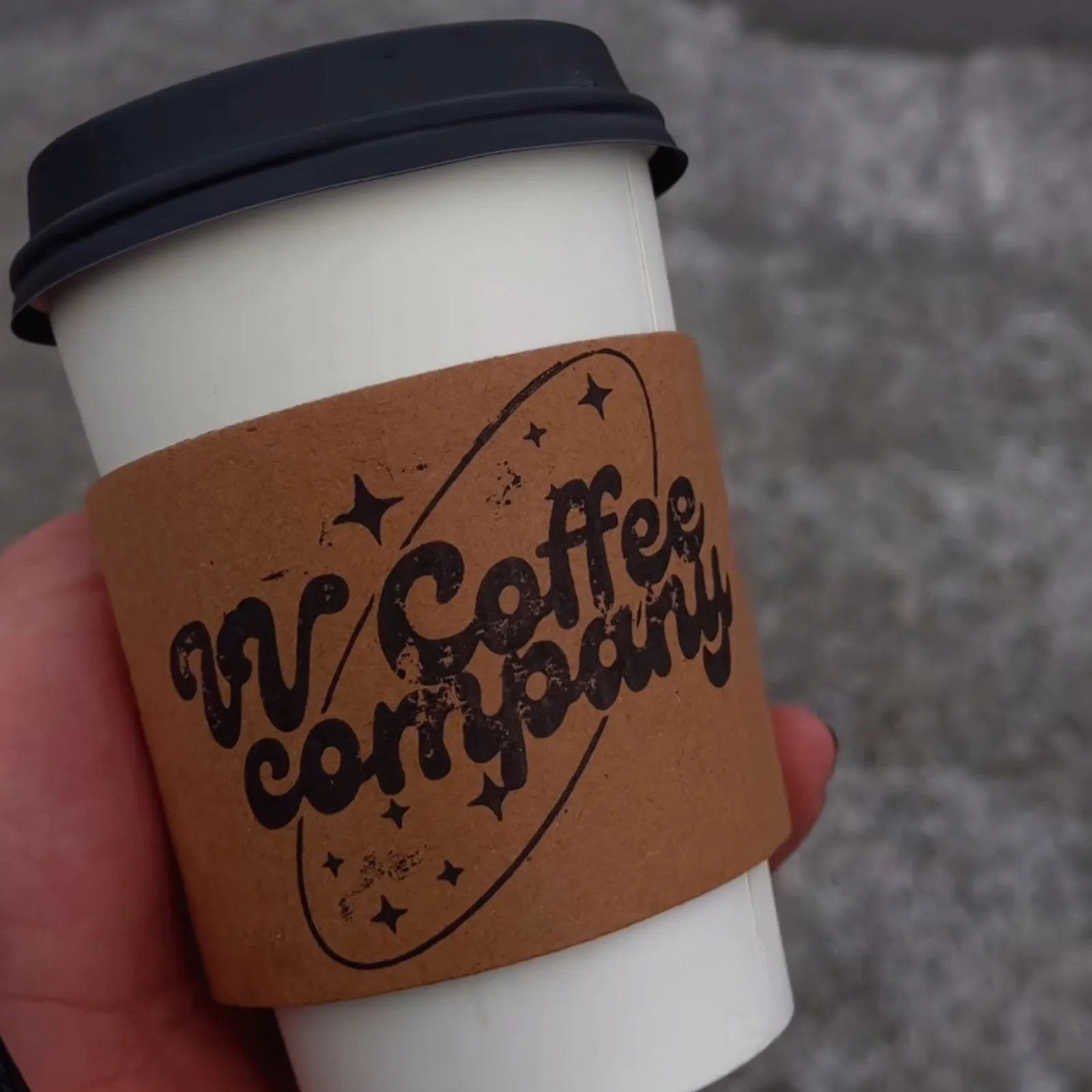 A hand holding a VV's Coffee cup